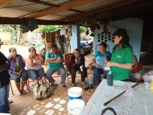 A Fundación Paraguaya field officer demonstrates a micro-franchise option, consisting of bottling and selling cleaning products, at a group meeting