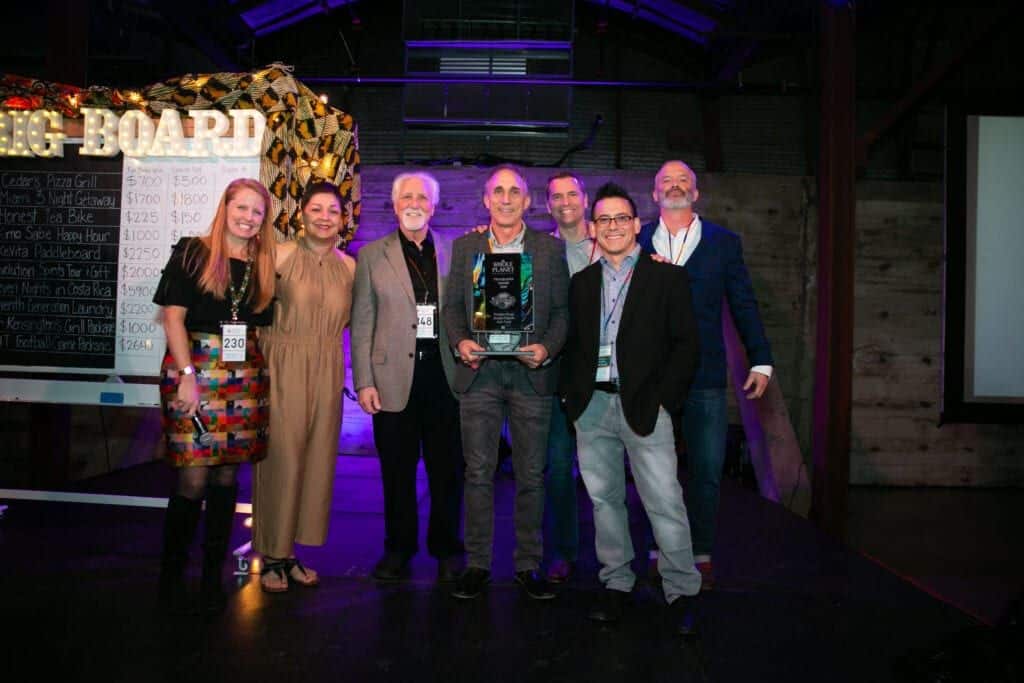 group of frontier representatives standing on stage receiving an award