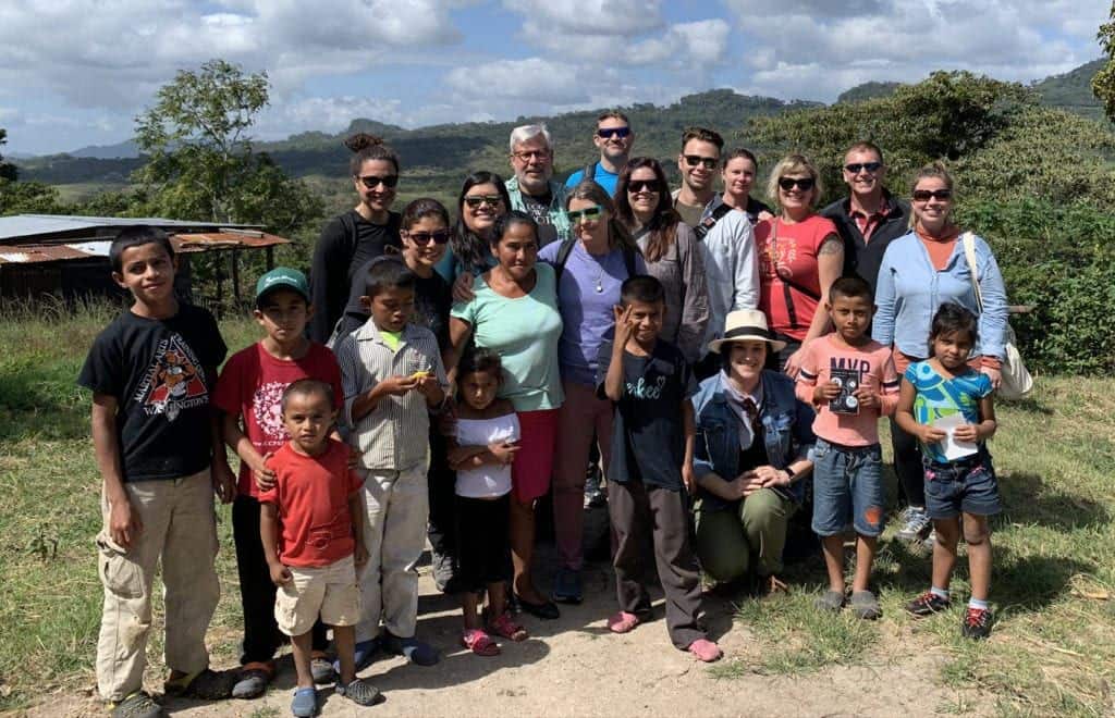 A group of people standing in front of a crowd posing for the camera

Description automatically generated